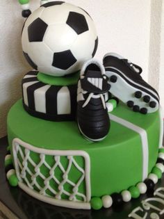 a cake with soccer shoes and a soccer ball on top