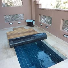 an indoor swimming pool in the middle of a tiled floor