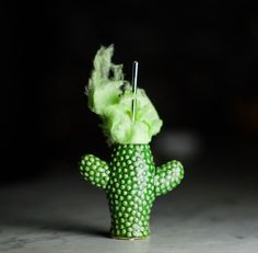 a green toy cactus with needles sticking out of it