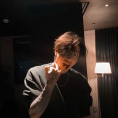 a man brushing his teeth in front of a mirror with the light shining on him