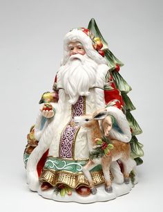 a santa claus figurine holding an apple next to a deer