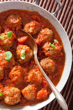 a white bowl filled with meatballs and tomato sauce