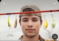 a young man wearing a hat with fishing hooks attached to his head