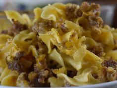 a bowl filled with pasta and meat covered in sauce