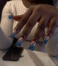 a woman with blue and white nail polish on her nails