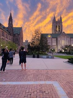 people are standing on the sidewalk in front of a building