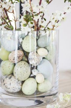 a vase filled with eggs and flowers on top of a table