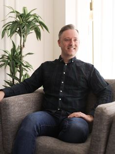 a man sitting in a chair with his legs crossed