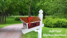 a mailbox sitting on the side of a road next to a lush green forest