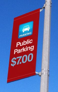 a red parking sign on top of a metal pole with a blue sky in the background