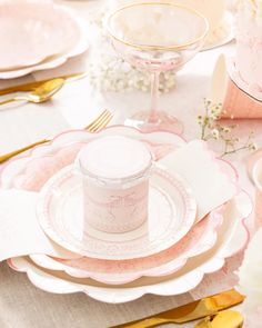 a table set with pink and white china