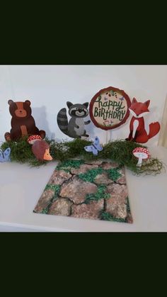 a table topped with lots of stuffed animals next to a sign that says happy birthday