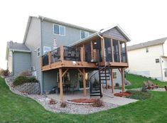 a house with a deck and stairs in the front yard