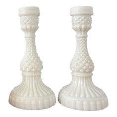 two white candlesticks sitting next to each other