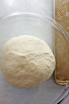 a ball of dough sitting in a glass bowl