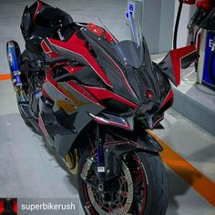 a red and black motorcycle parked in a garage