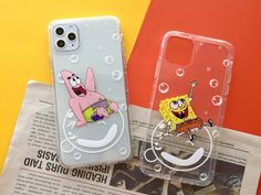 two phone cases with cartoon characters on them sitting on top of a newspaper next to each other