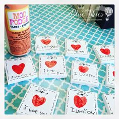 some cards with hearts on them and a bottle of glue sitting next to the cards