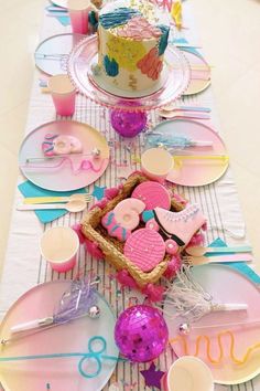 a table set up with plates, cake and other items for a birthday or baby shower