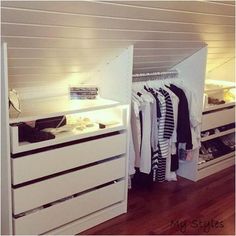 a closet with drawers and clothes on hangers