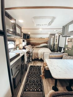 the interior of a camper with two beds and a kitchen area in front of it