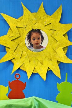 a child's face is seen in the center of a sun - shaped mirror