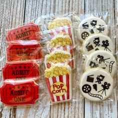 some cookies that are sitting on top of plastic wrappers with popcorn and movie tickets