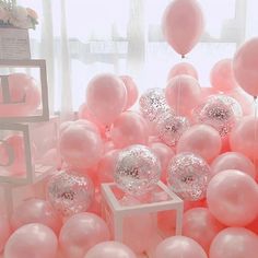 there are balloons and other items in the room that is decorated with white and pink