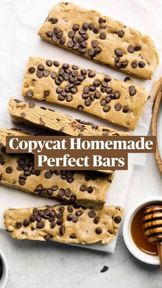 chocolate chip cookie bars on parchment paper with honey and spoons next to the slices