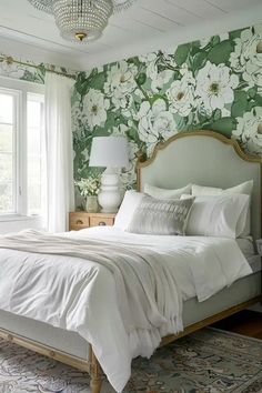 a bedroom with green floral wallpaper and white bedding, along with a chandelier