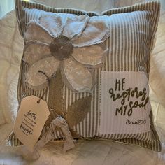 a pillow with a flower on it and a tag attached to the back of it