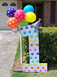 a number one made out of paper with balloons in the shape of a birthday hat