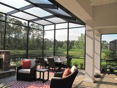 a covered patio with chairs and tables next to a fire place