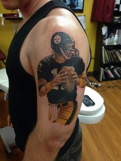 a man with a football tattoo on his arm