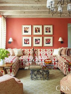 a living room filled with furniture and pictures hanging on the wall above it's coffee table