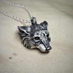 This piece will be handmade for you in the United Kingdom. Please allow me up to 28 days to finish making it. This Silver Wolf has been hand made in the United Kingdom. Grey wolves (Canis lupus), are found in various guises throughout remote areas of the Northern Hemisphere. They have been an essential element in the folk law and literature of almost all cultures and ages.She-wolves are the epitome of maternal protection and feminine strength, they were particularly prevalent in Roman legend and also the title given to England’s war-like medieval queens. The sterling silver wolf measures around 2.5cm (which is close to an inch). It has eyes made from natural, cabochon cut, 4mm grey moonstone gemstones. The silver wolf has been hung from an elegant, yet sturdy 20 inch long solid silver chai Sterling Silver Wolf Design Jewelry, Silver Wolf Pendant Necklace, Silver Wolf Design Pendant Necklace, Silver Wolf Design Round Pendant Necklace, Silver Necklace With Wolf Design Round Pendant, Silver Round Pendant Necklace With Wolf Design, Moonstone Eyes, Grey Wolves, Feminine Strength