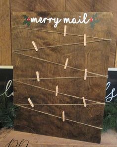 a wooden sign with clothes pins attached to it and merry mail written on the front