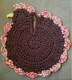 a crocheted placemat with a brown bear on the center and red, white, and yellow stripes