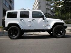 a white jeep is parked on the street