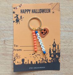 a happy halloween keychain hanging from a card