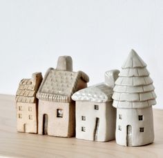 three ceramic houses sitting on top of a wooden table