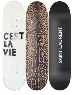 three skateboards with different designs on them, one is white and the other is black