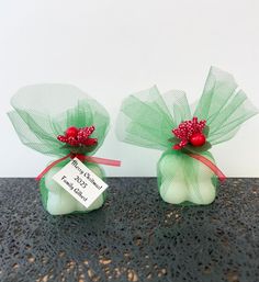 two green organ bags with red berries on them and a price tag hanging from the top