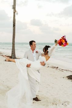 a bride carrying her groom on the beach