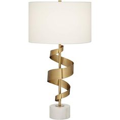 a table lamp with a white shade on it and a gold - plated base