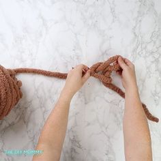 someone crocheting a knot on top of a marble counter