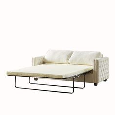 a white couch with a pull out bed on it's backrest and two pillows