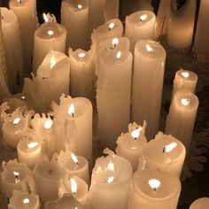 many white candles are lined up in rows