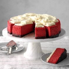 a red velvet cake with white frosting and two slices cut out on the plate