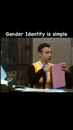 a man in a yellow sweater holding up a pink folder with the caption gender identity is simple